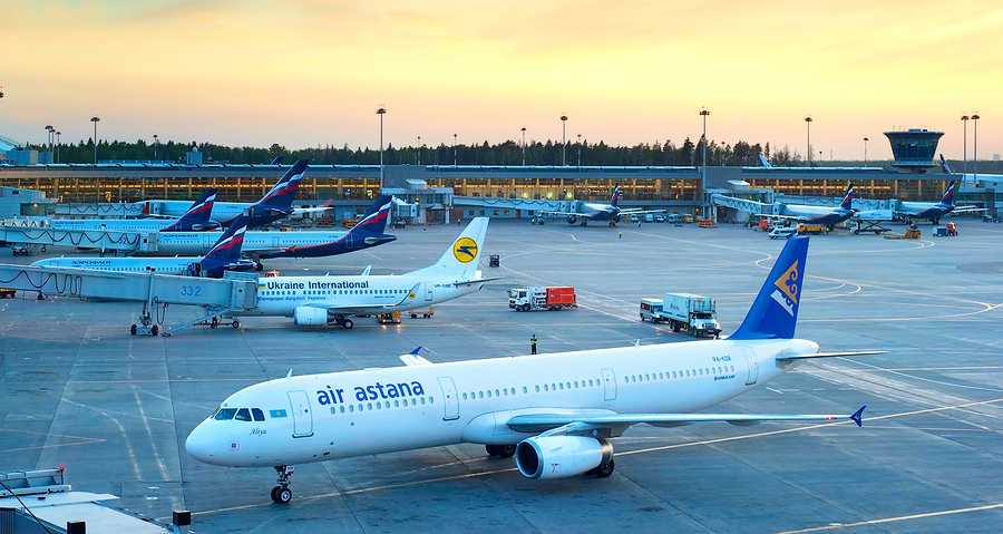 avion de la aerolina air astana parado en el aeropuerto y a su lado 5 aviones mas de otras aerolineas