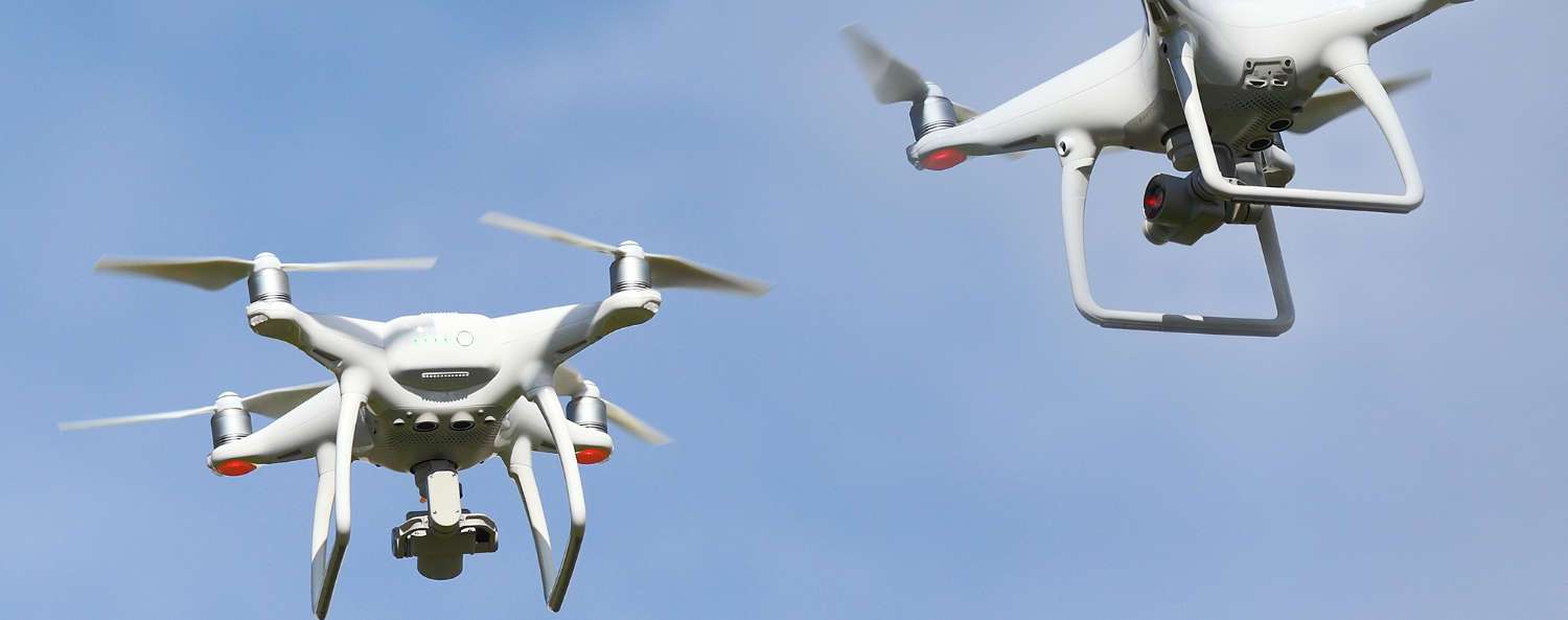 dos drones dji phantom en vuelo con fondo azul claro
