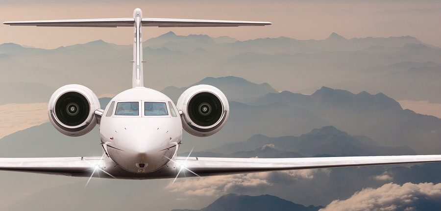 vista frontal de avion blanco con fondo de montanas y nubes