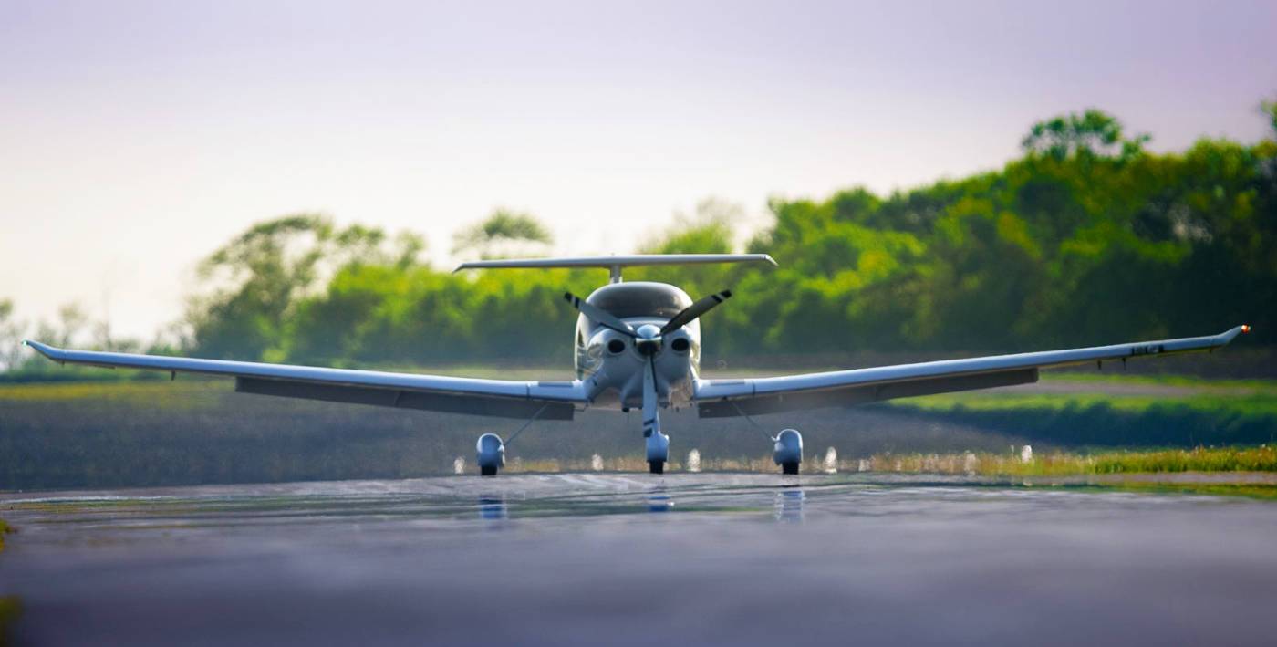 avioneta aterrizada en pista con fondo de vegetacion verde