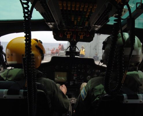 Dos pilotos dentro de la cabina de un helicoptero del ejercito