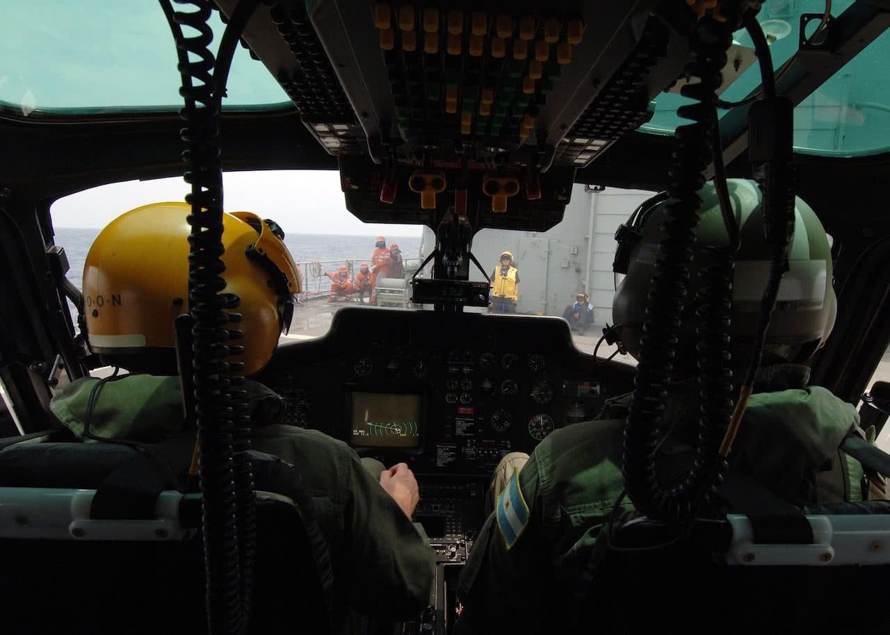 Dos pilotos dentro de la cabina de un helicoptero del ejercito