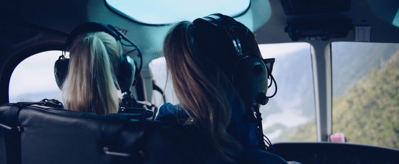 dos chicas piloto con sus cascos de comunicacion puestos en la cabina de un avión