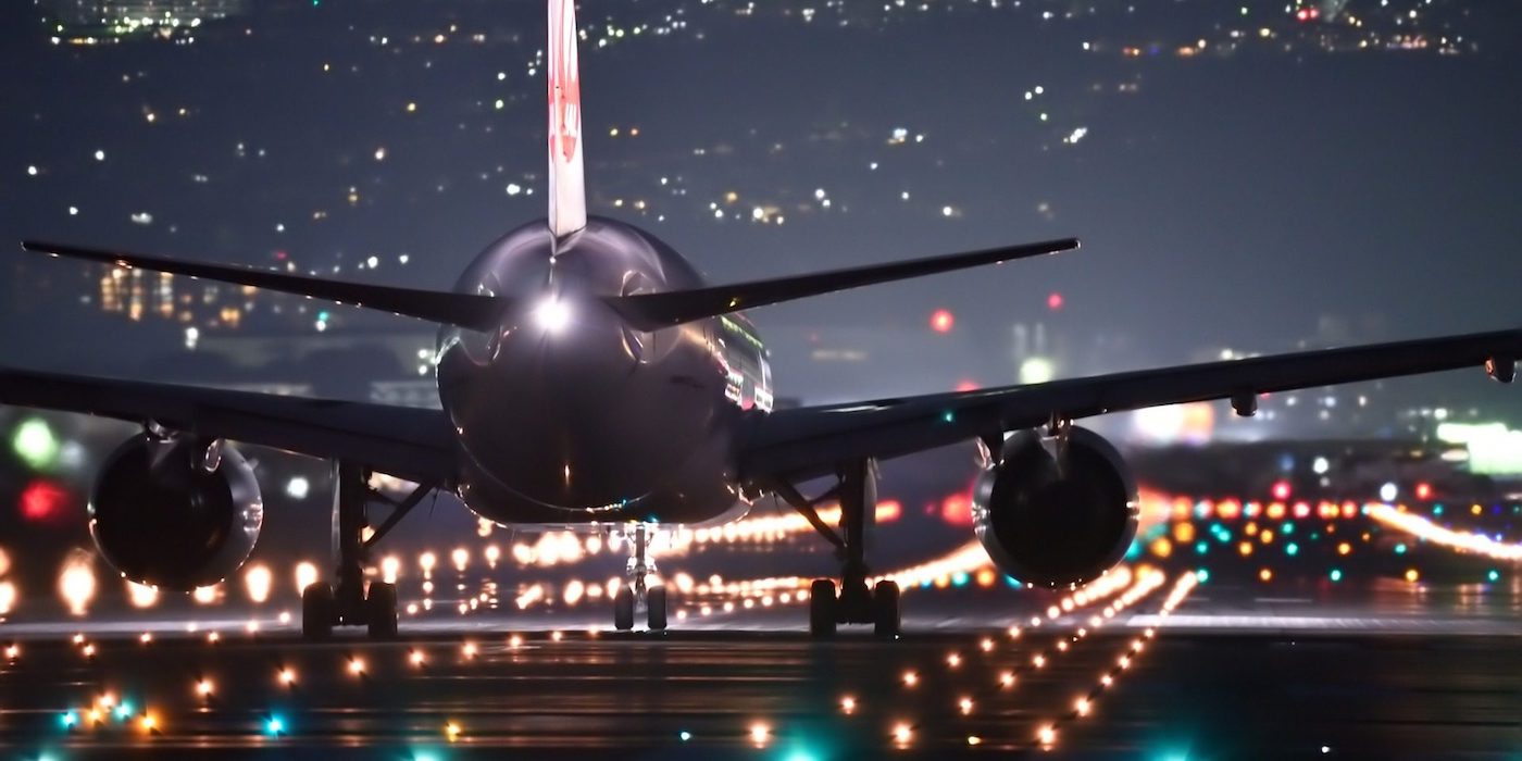 trasera de avion de pasajeros avansando en pista de despegue de noche