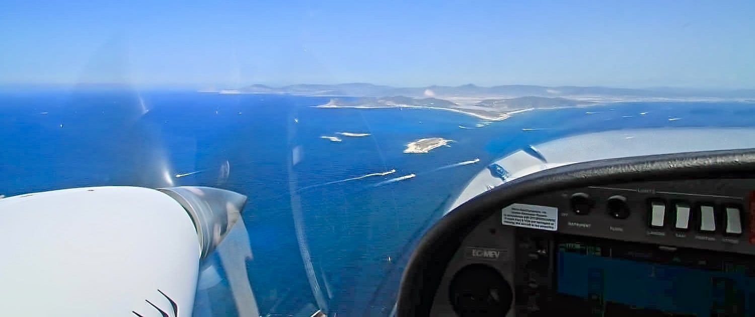 helice y mandos de avion con paisaje de islas desde el aire