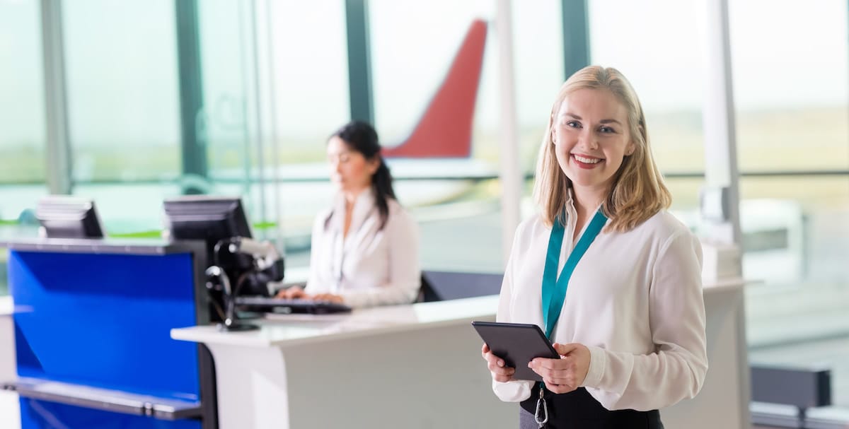 auxiliar de vuelo en aeropuerto atendiendo a pasajeros