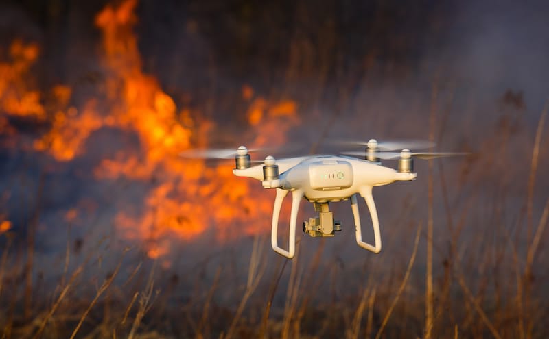 Dron volando sobre un incendio para controlar avance de las llamas.