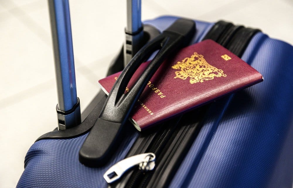 Maleta de mano y pasaporte para viajar en avión.