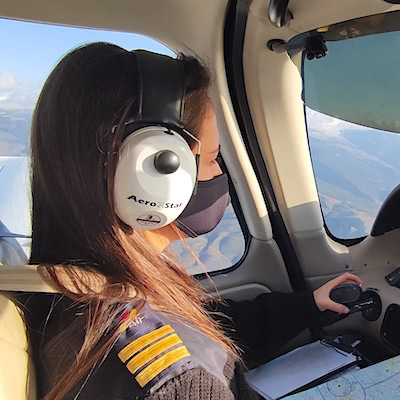 Alumna piloto de avión volando sobre Málaga para obtener su licencia.