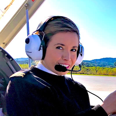 Mujer piloto en aeropuerto a la espera de comenzar su vuelo.