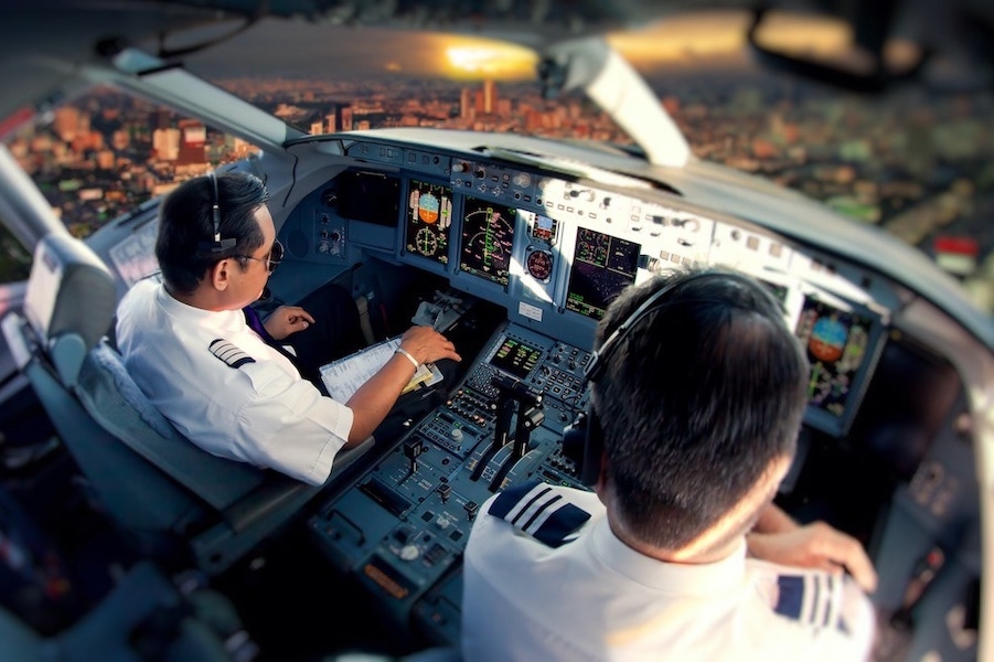 Dos pilotos en un avión realizando tareas de revisión