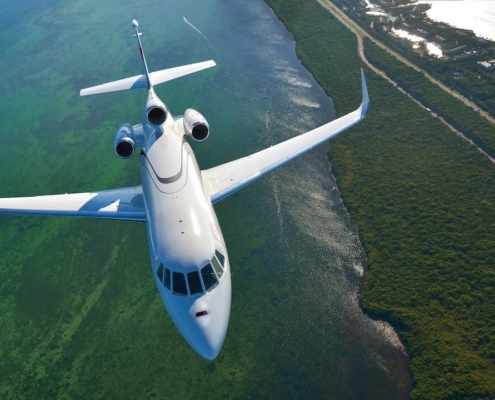 Avión de tres motores sobrevolando un lago