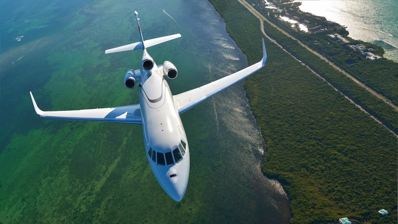 Avión de tres motores sobrevolando un lago