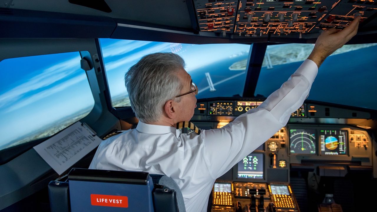 Cabina de piloto con un comandante manejando el panel de control